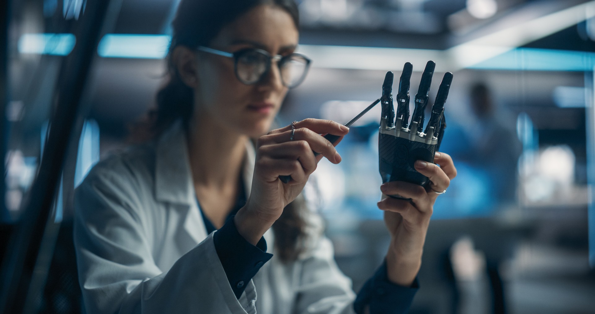 Portrait of Young Female Scientist Working in Technological Research and Development Company, Assembling an Innovative Bionic Prosthetic Hand. Engineer Working on Technology for Physically Impaired